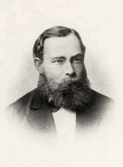 Sepia-toned black-and-white photograph of a young Gottlob Frege in a dark jacket, with beard and a serious gaze, taken around 1879