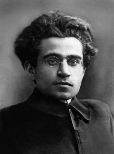 Black-and-white portrait of Antonio Gramsci: a young man with glasses, thick hair, and a serious gaze