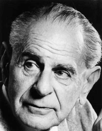 Black-and-white portrait of Karl Popper: a bespectacled, serious middle-aged man