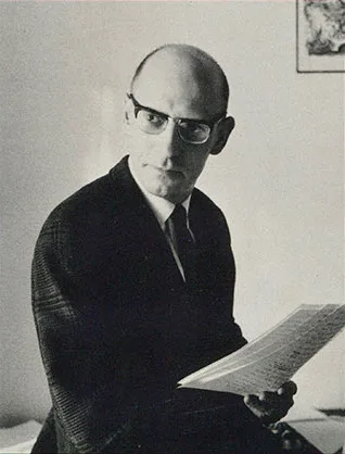 Photograph of Michel Foucault, 1970: bald, bespectacled, looking out at the viewer with a fully open smile