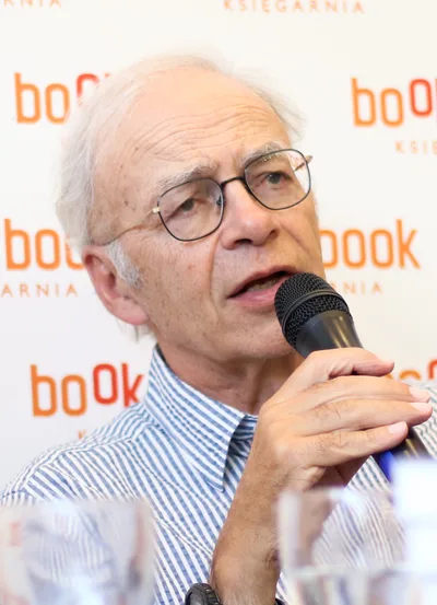 A 2017 photograph of Peter Singer: a middle-aged man with glasses in a light shirt, speaking