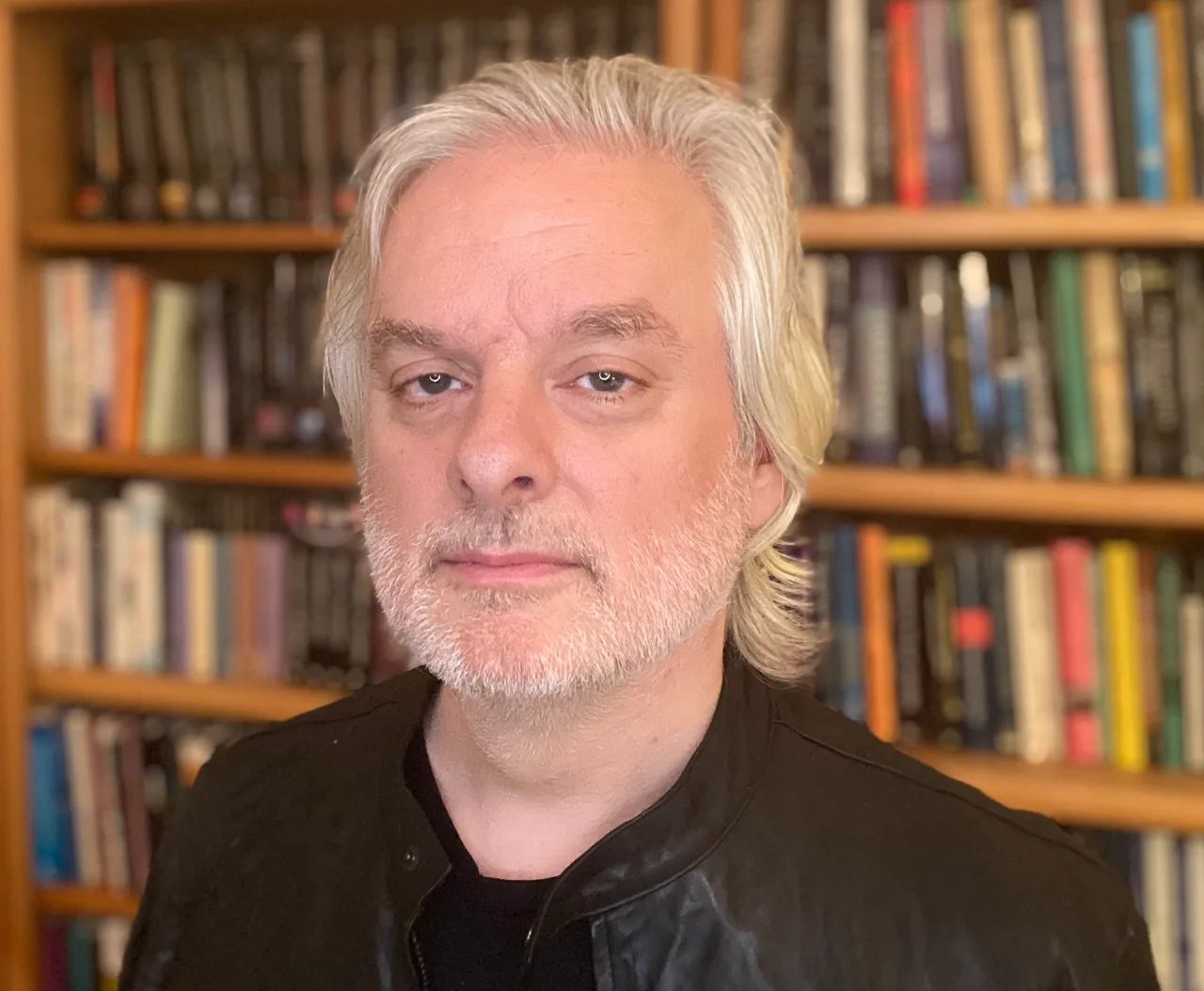 A photograph of David Chalmers: an Australian-American philosopher with long hair, lecturing with his arms open